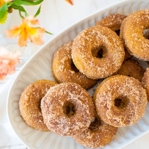 snickerdoodle banana baked donuts on a platter on a marble countertop.
