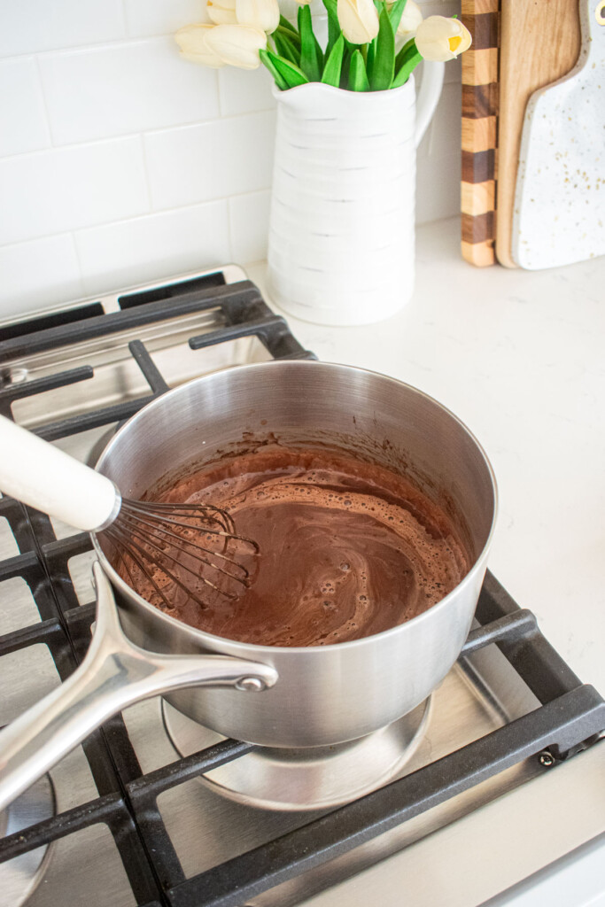 eggless chocolate peanut butter pudding being whisked over the stovetop.