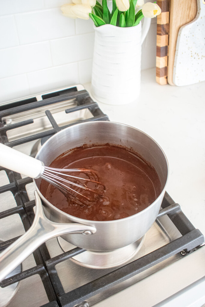 eggless chocolate peanut butter pudding being whisked over the stovetop.