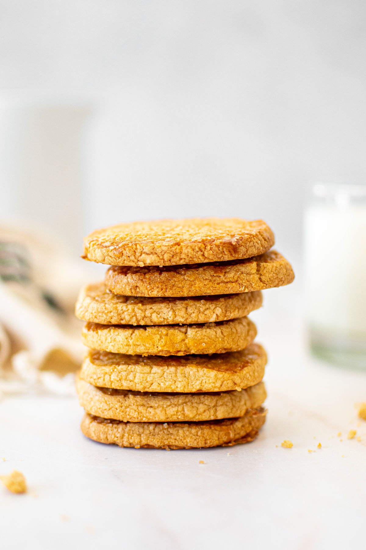 stack of kamut flour shortbread cookies on a marble table with a glass of milk.