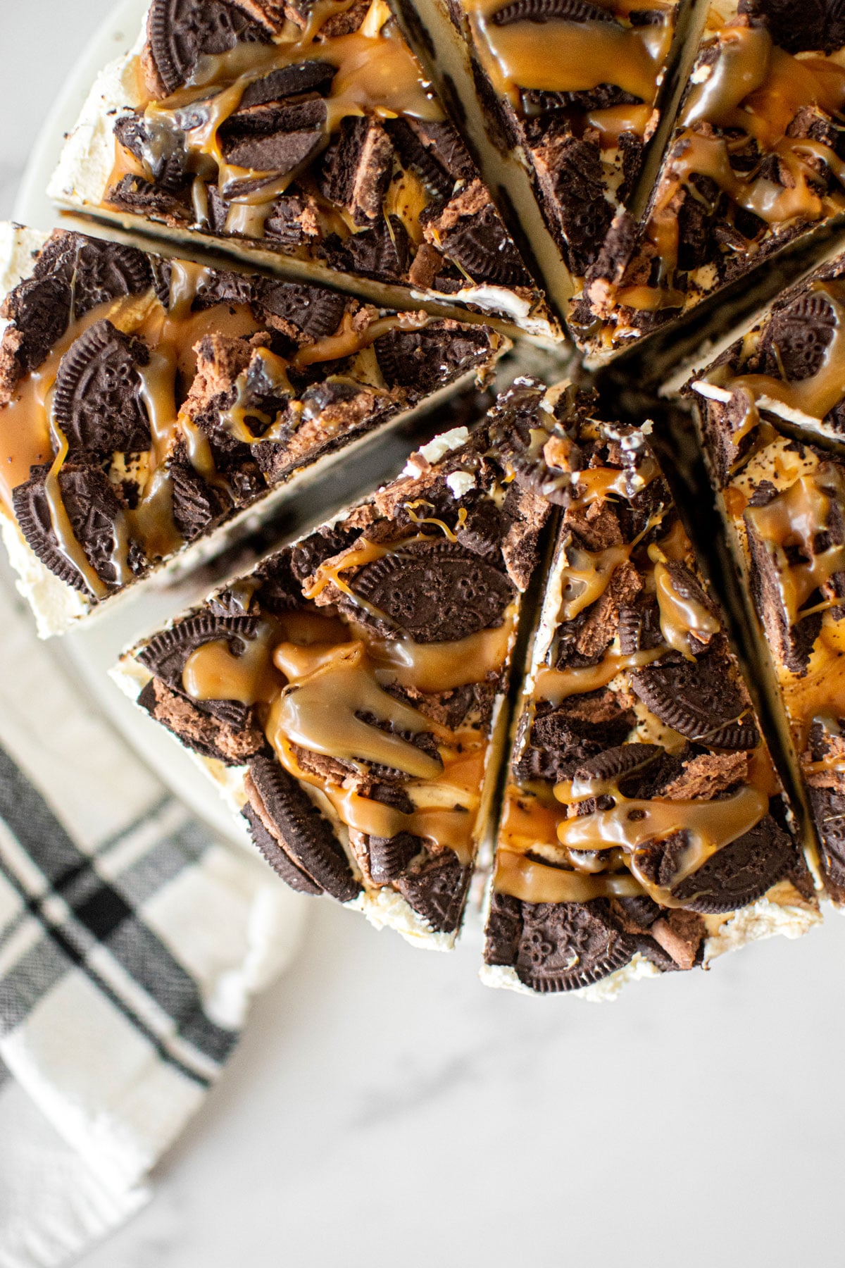 caramel chocolate oreo icebox cane cut into slices on a white marble serving board.