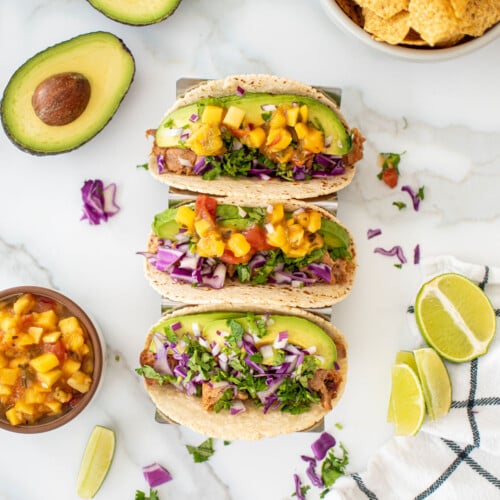 chili lime ahi fish tacos in a taco tray on a white marble countertop.