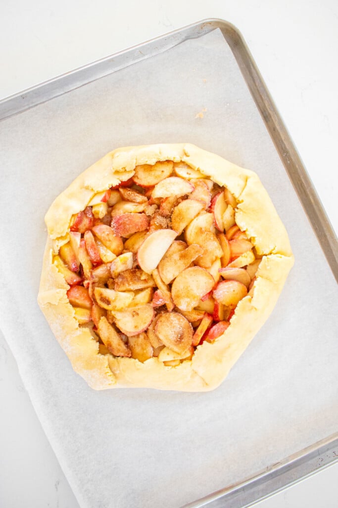 sourdough peach galette on a baking sheet.