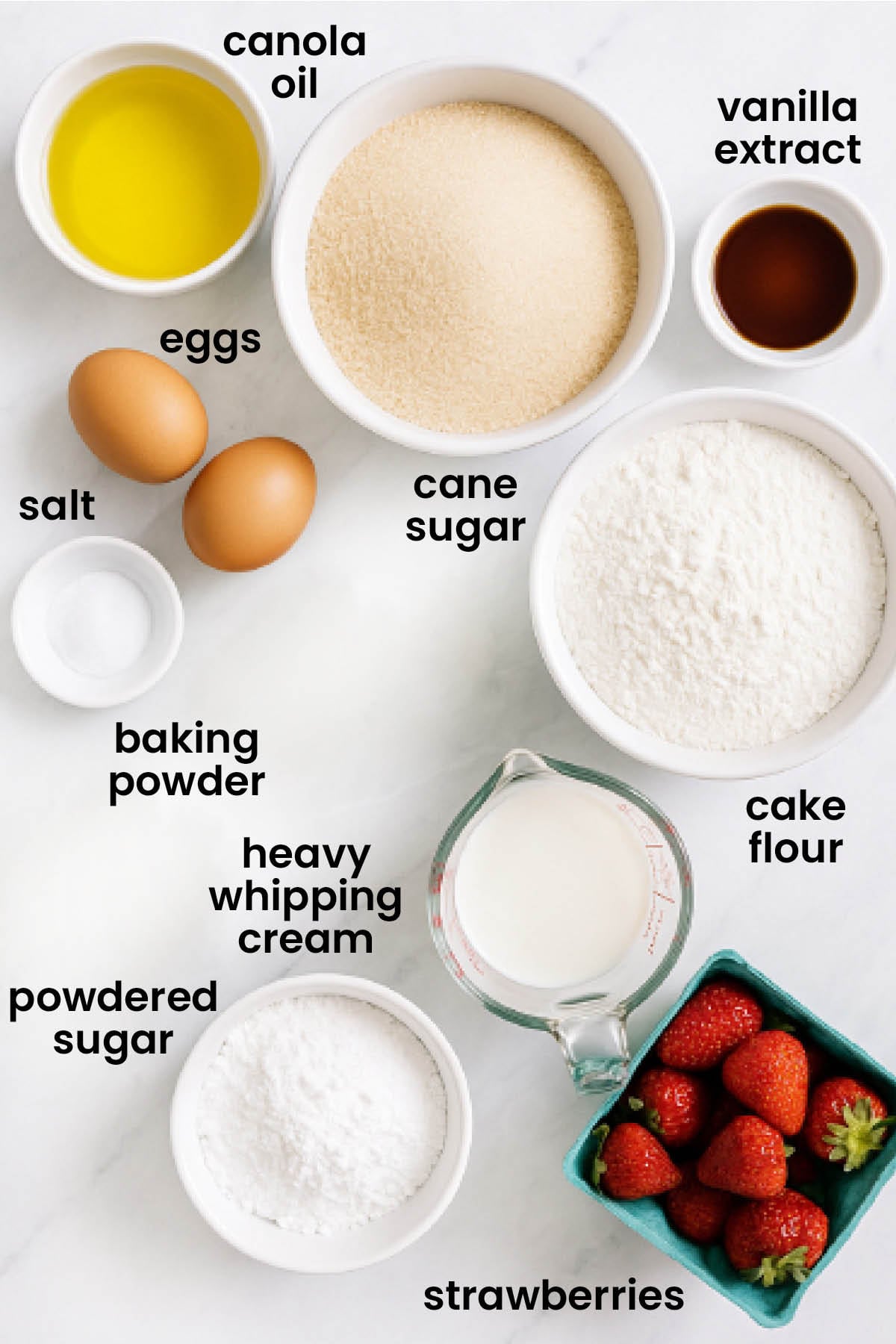 individual ingredients for strawberry shortcake cupcakes laid out against a white background.