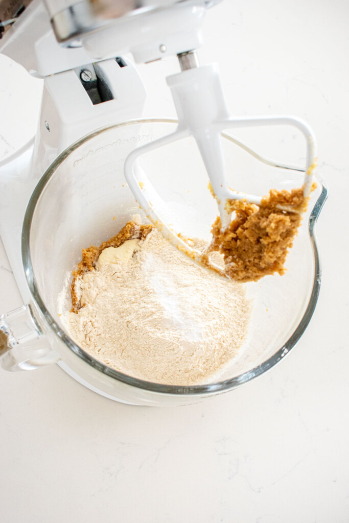 ingredients for chocolate caramel smore bars in a glass mixing bowl on a white marble counter.