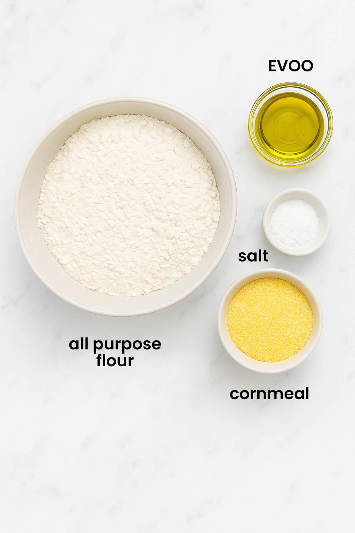 individual ingredients for homemade flatbread pizza dough laid out against a white background.