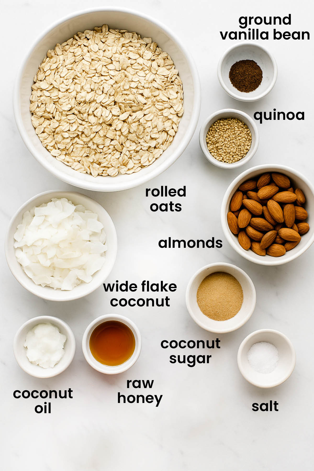 individual ingredients for honey almond coconut granola laid out against a white background.