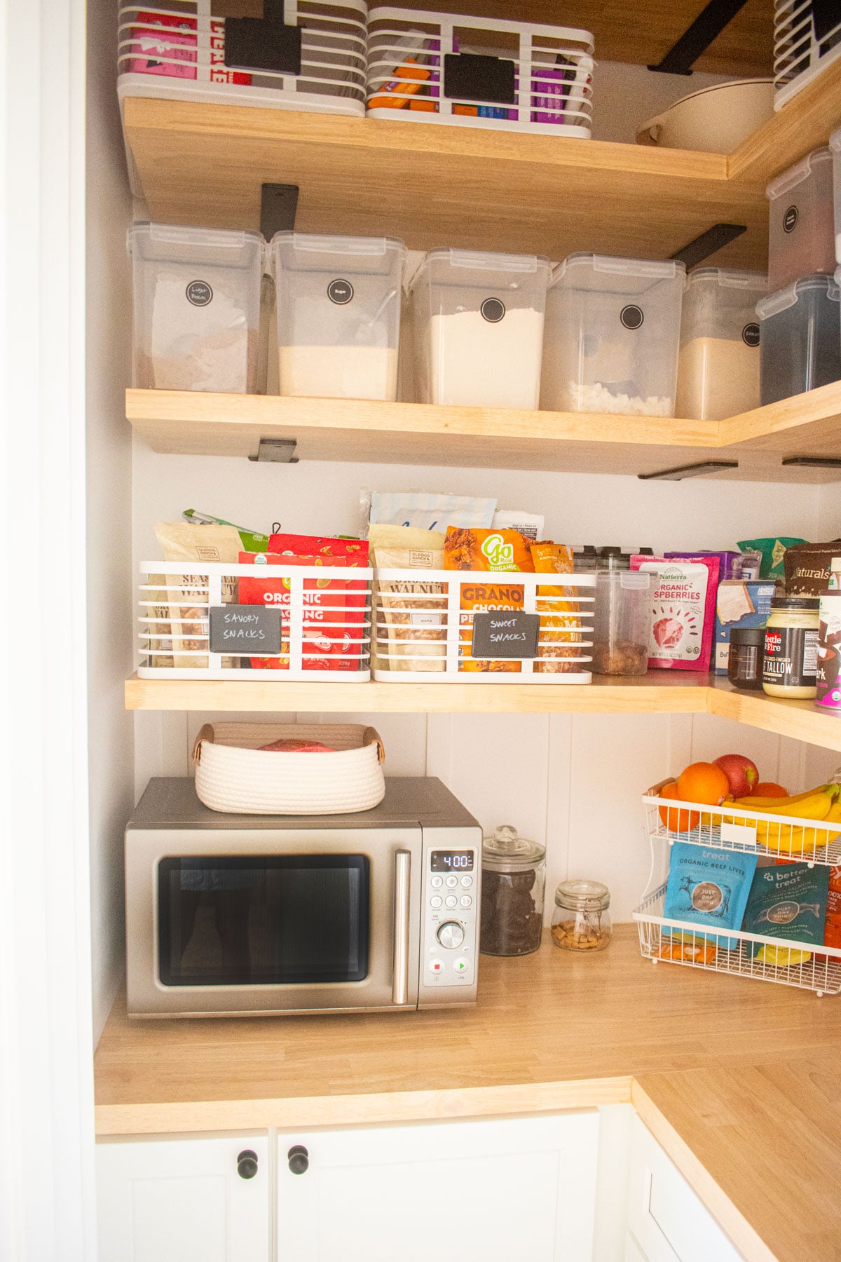 diy kitchen corner pantry wood counter with microwave and storage bins on the shelves.