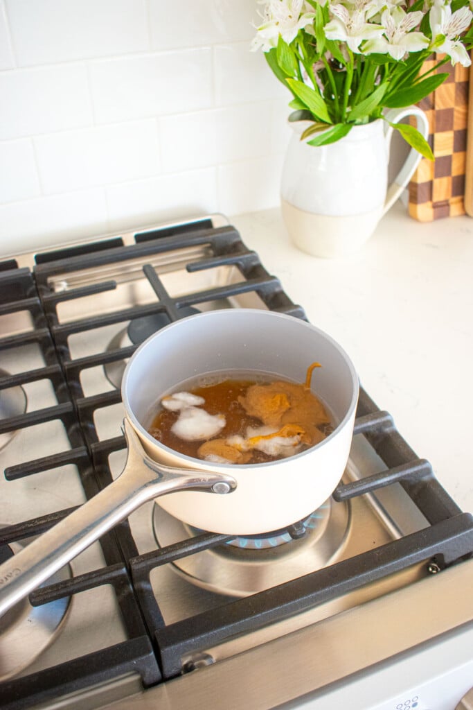 wet ingredients for peanut butter honey granola in a small pot on top of a stovetop.