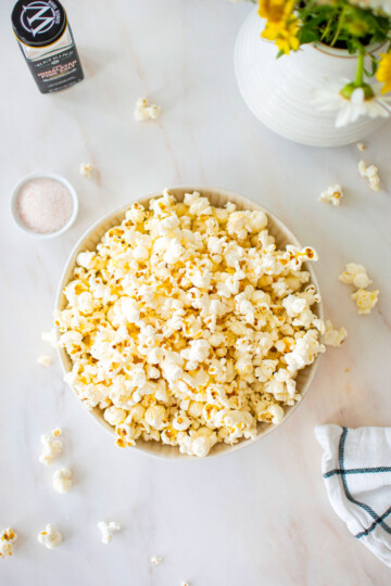 pink himalayan sea salt popcorn in a bowl on a marble coungtertop.