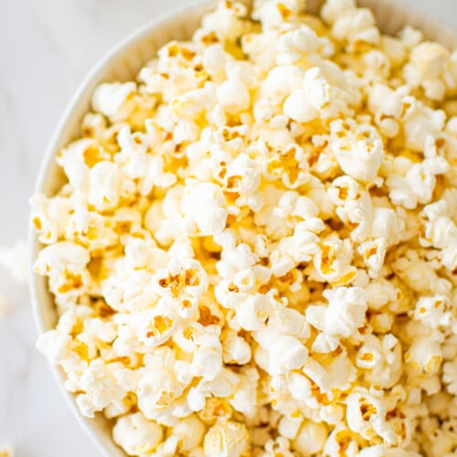 pink himalayan sea salt popcorn in a bowl on a marble coungtertop.