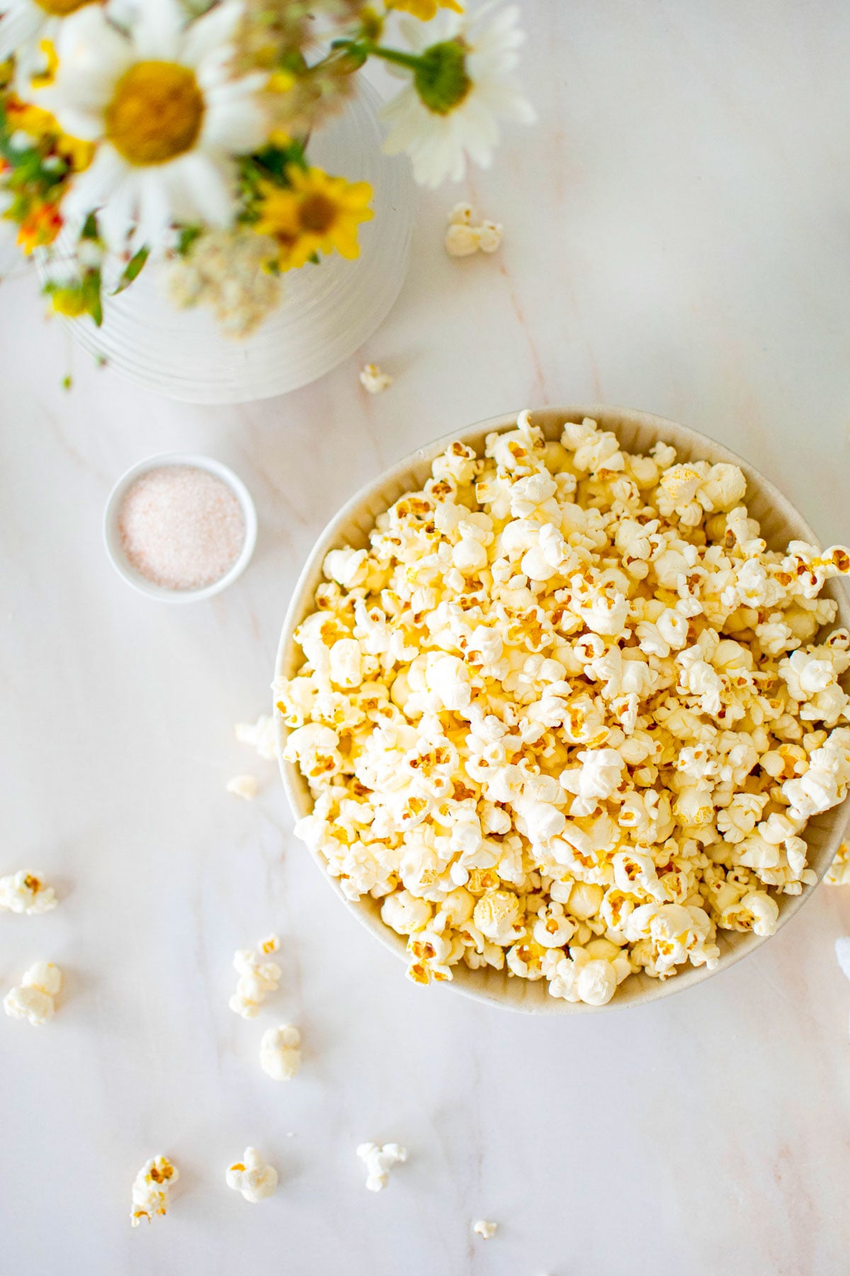 pink himalayan sea salt popcorn in a bowl on a marble coungtertop.