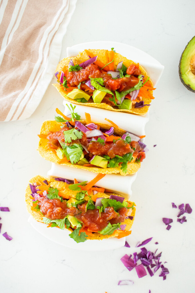 taco try with 3 bbq chicken tacos on a white marble counter.
