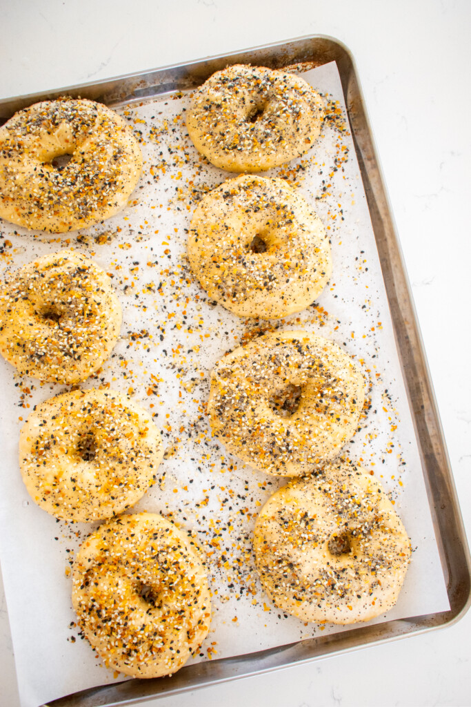 bone broth everything bagel dough sprinkled with everything bagel seasoning on a baking sheet.