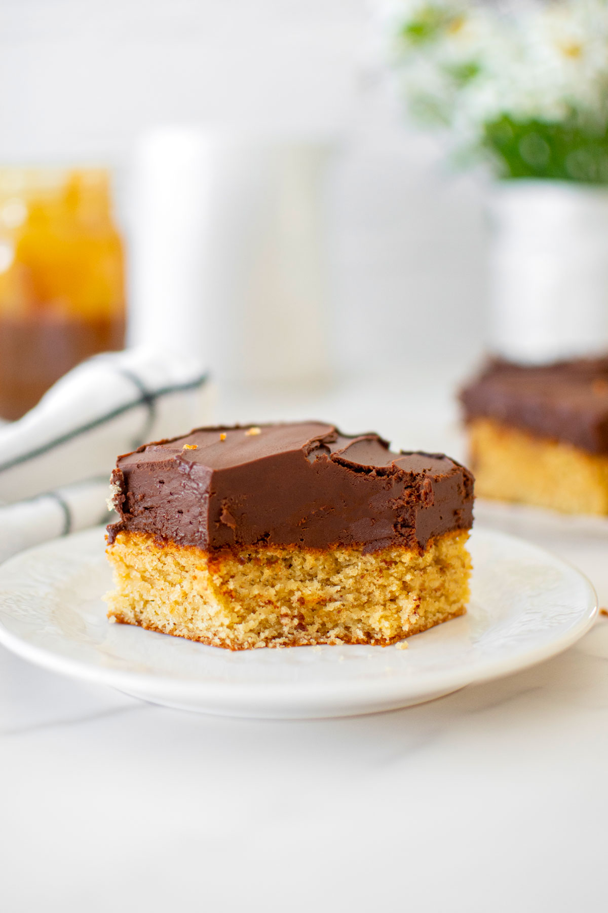 chocolate peanut butter banana cake slice on a plate with a bite taken out on a white marble table.