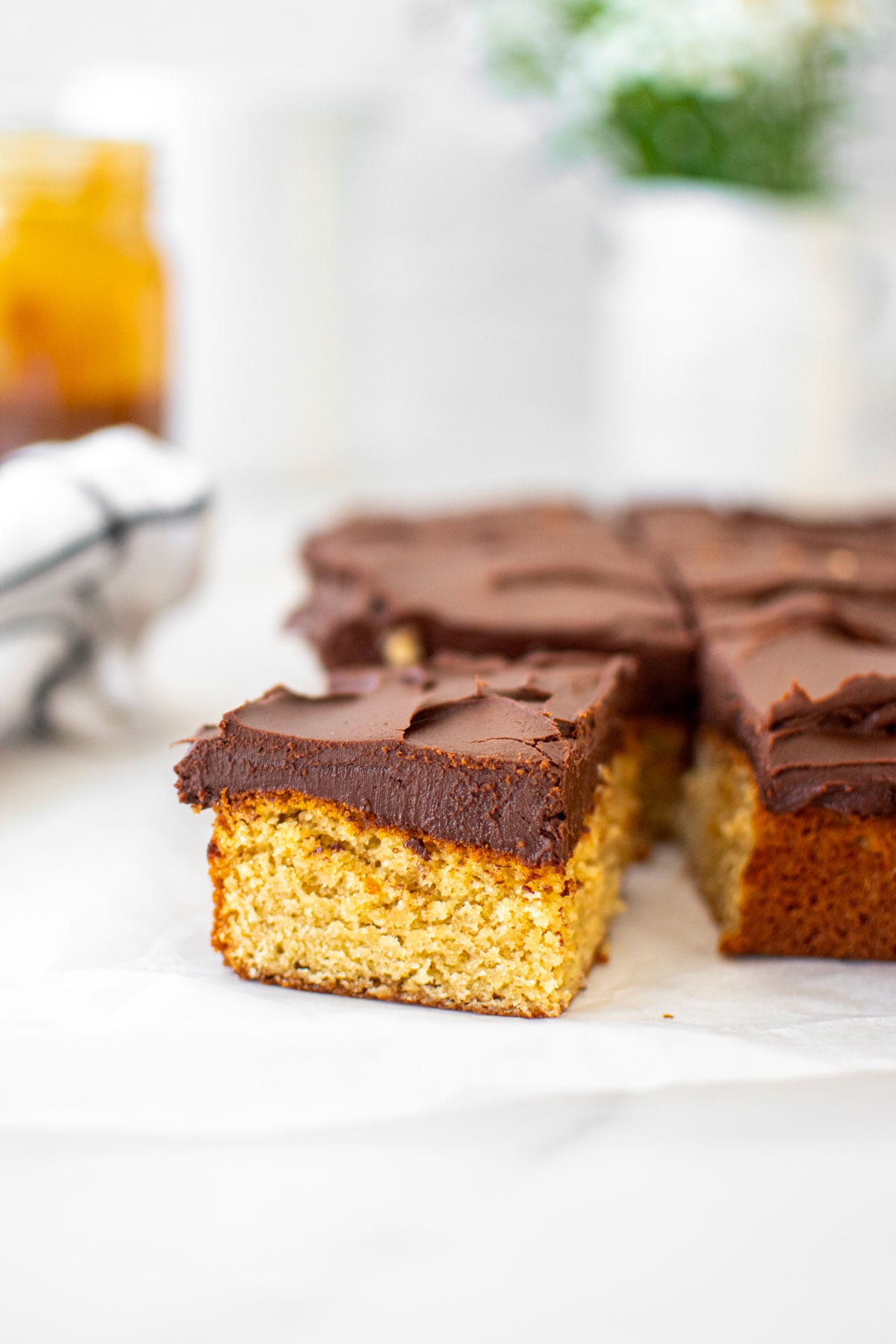 chocolate peanut butter banana cake cut into square slices on a white marble table.