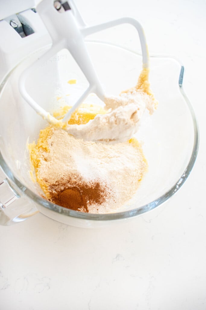 ingredients for soft baked snickerdoodle sandwich cookies in a glass stand mixing bowl on a marble counter.