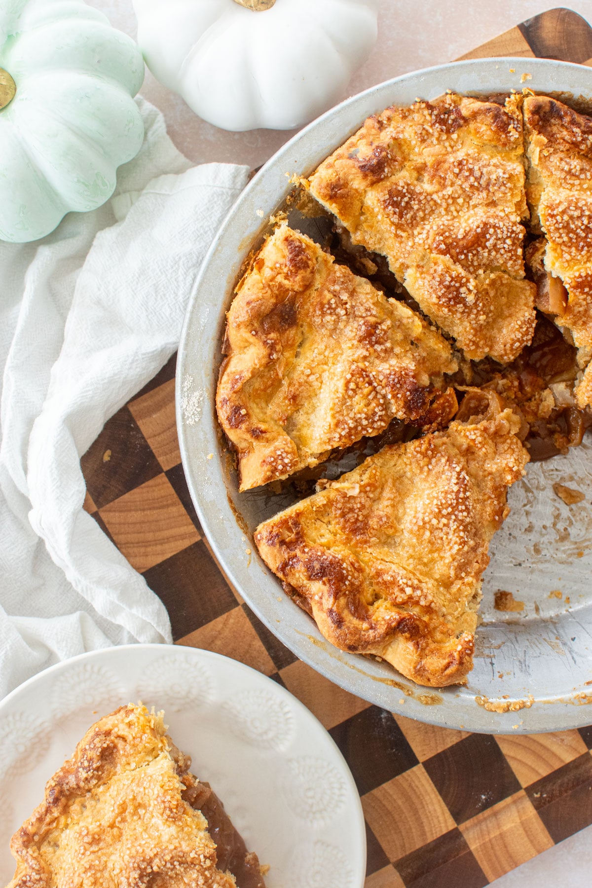 sliced sourdough apple pie on a checkered cutting board.