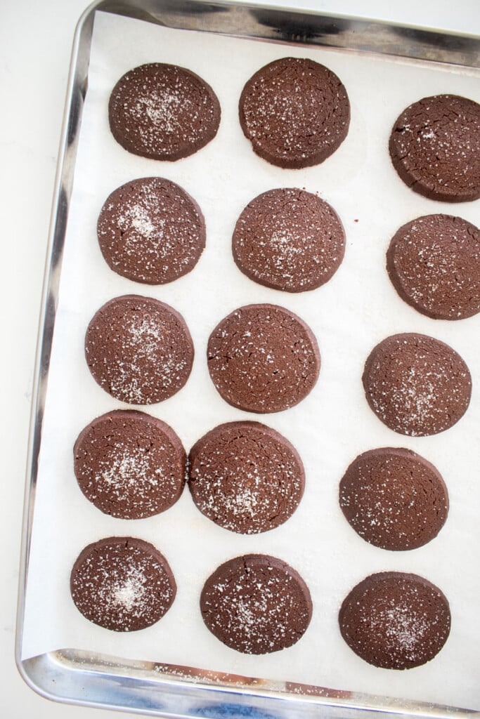 baked sourdough chocolate shortbread cookies on a baking sheet on a marble counter.