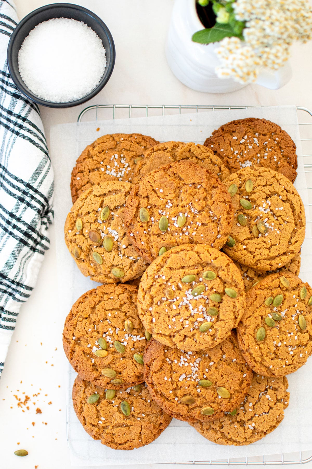 vegan pumpkin spice almond butter cookies on a cooling rack on a marble counter.