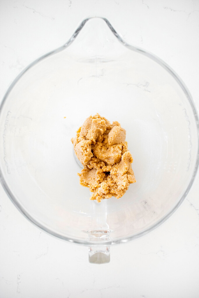 creamed shortening and sugar in a glass mixing bowl on a white countertop.