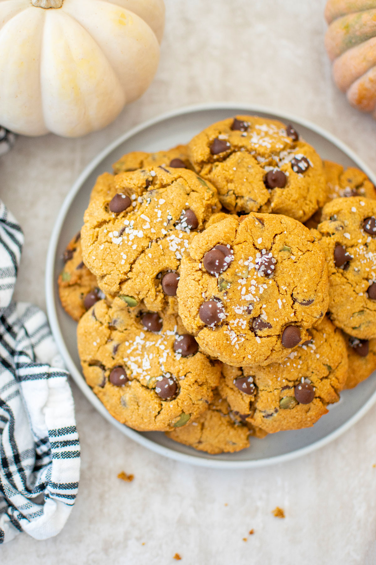 gluten free pumpkin chocolate chip cookies on a plate with pumpkins in background.
