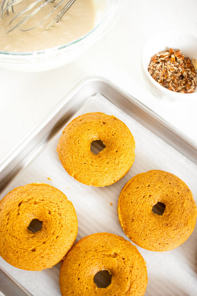 maple pumpkin spice baked donuts on a baking sheet.
