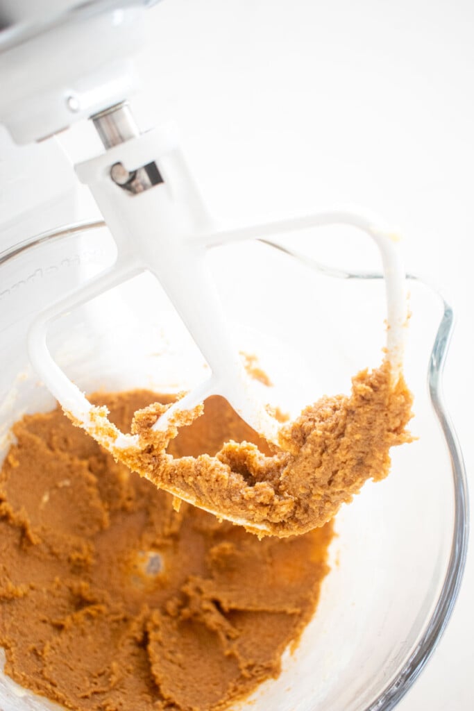 creamed butter and brown sugar in a glass mixing bowl on a marble counter.