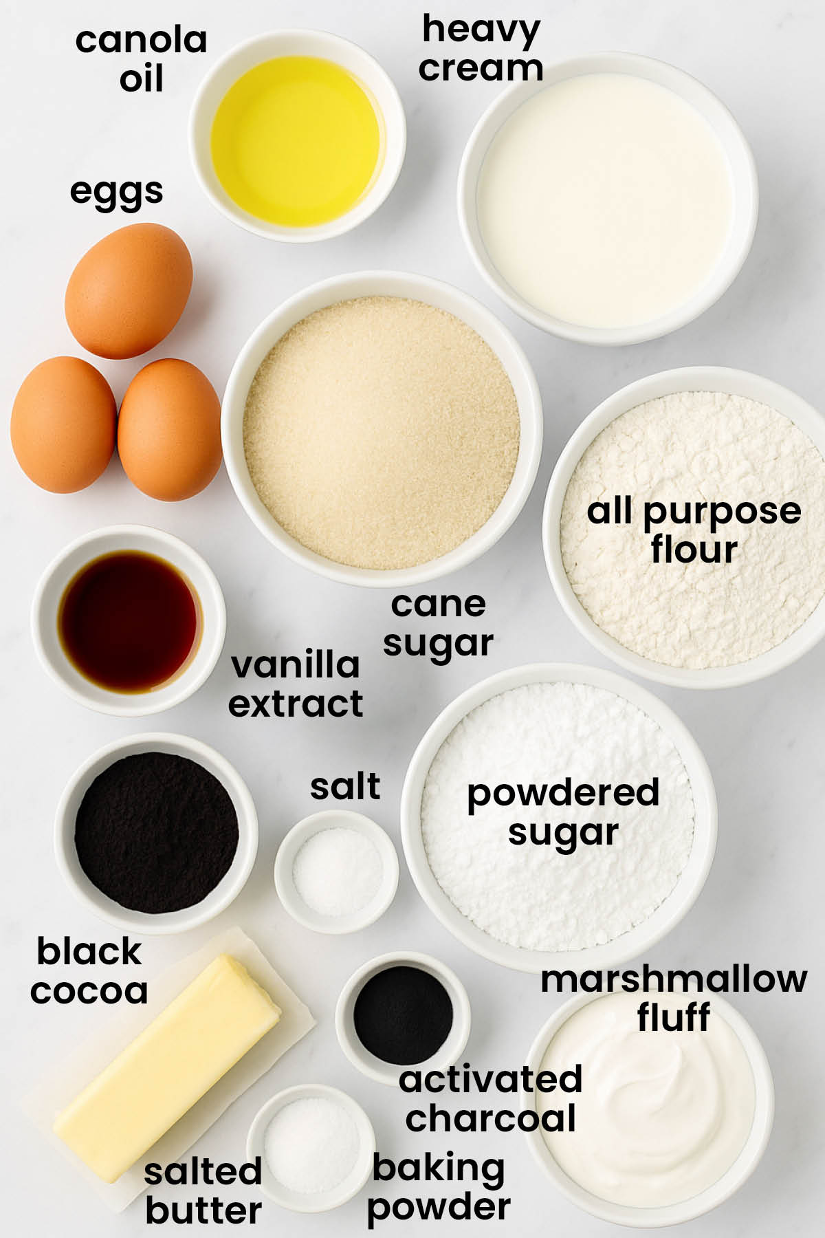individual ingredients for spooky rose halloween cake on a white marble kitchen countertop.