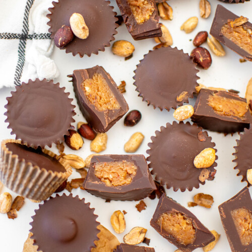 vegan dark chocolate mini peanut butter cups on a white marble counter.