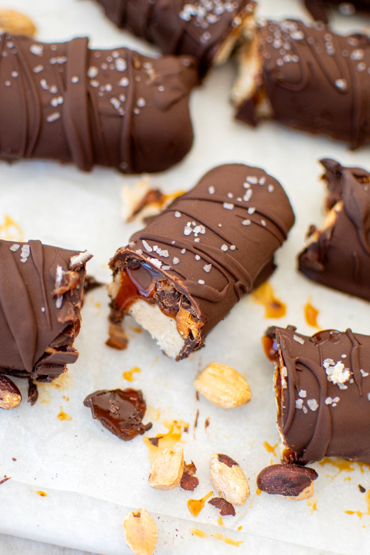 vegan snickers bar cut in half with more around on a marble board.