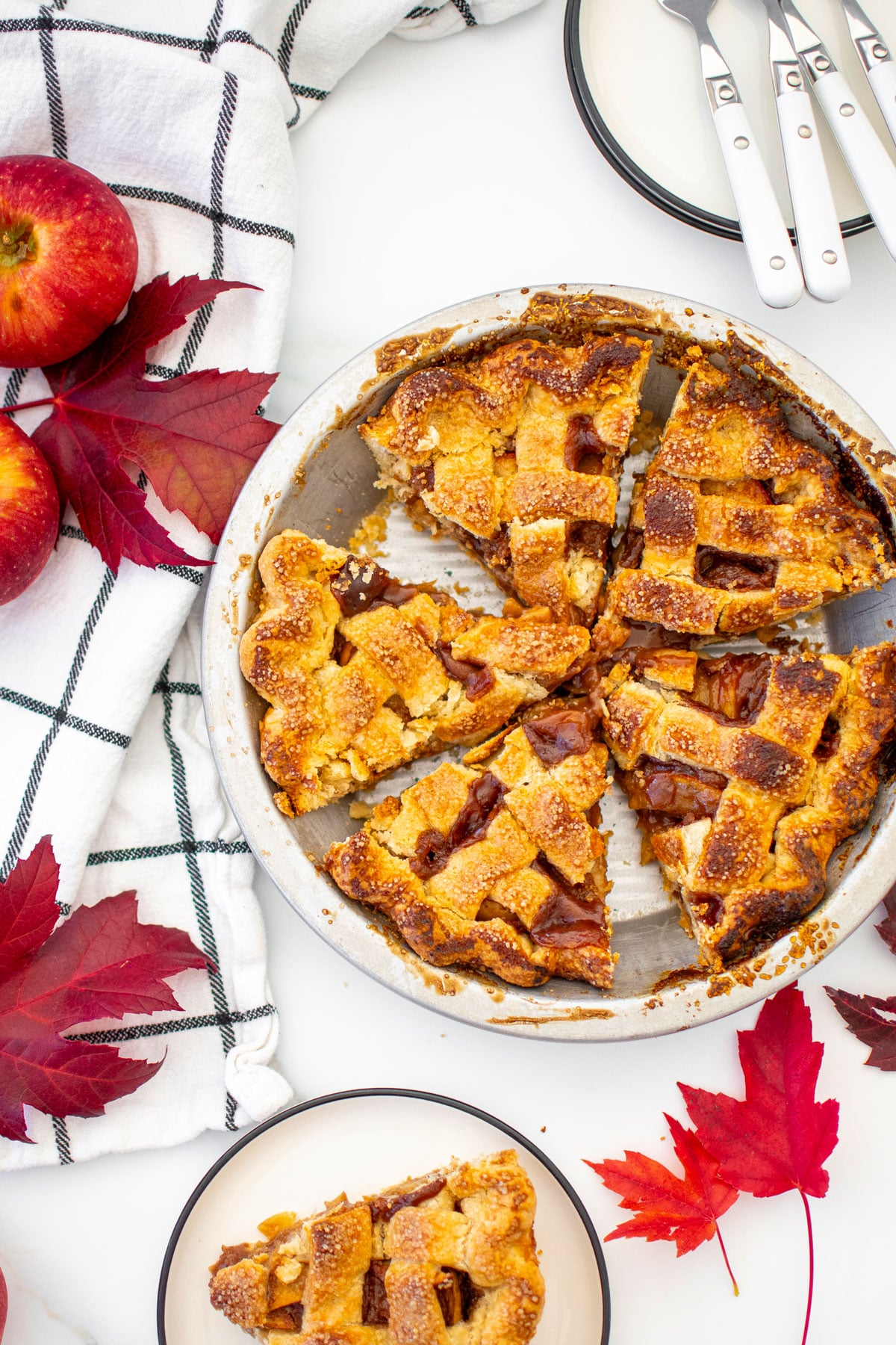 brown sugar honey apple pie sliced in a aluminum pie pan on a white marble counter.