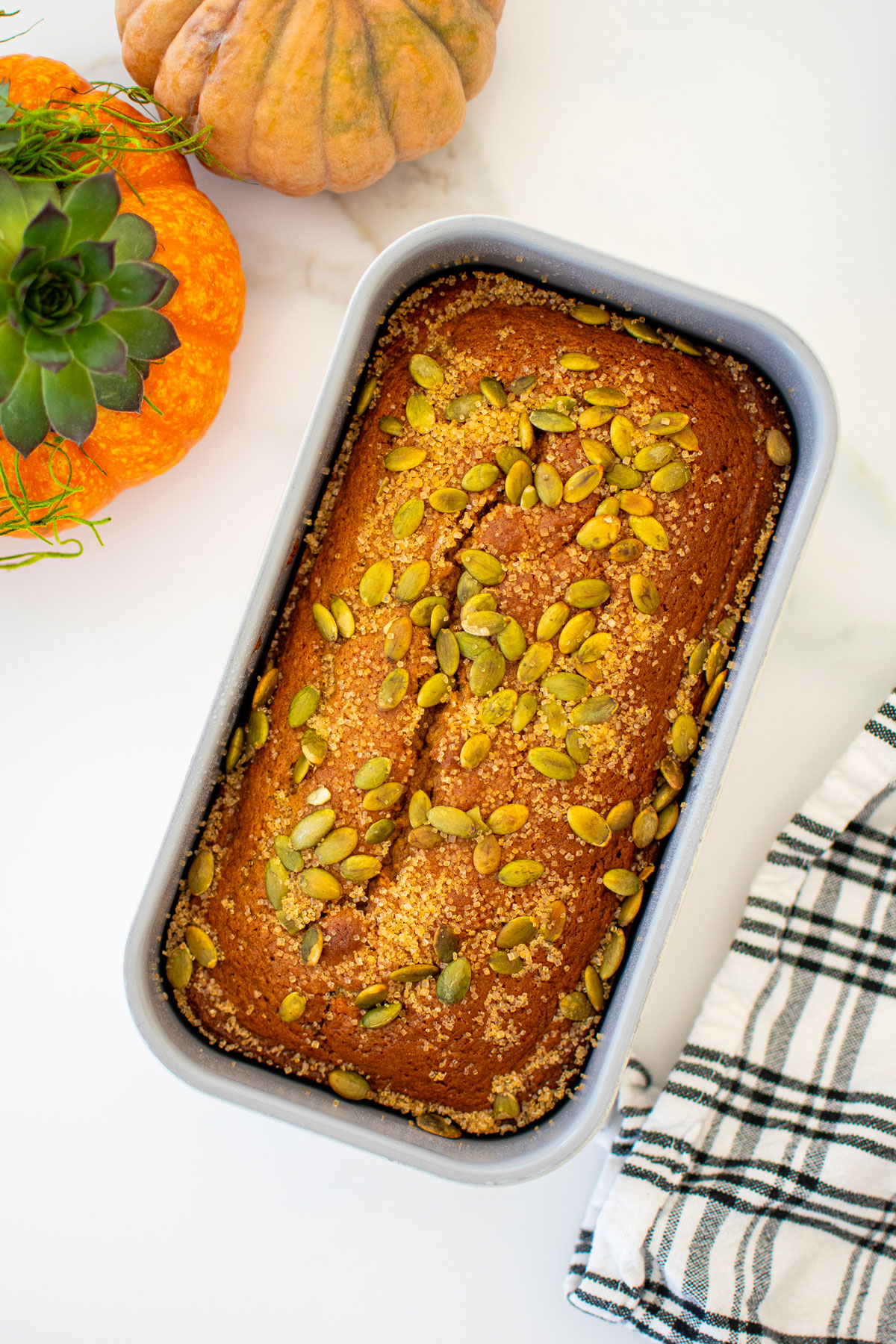 cinnamon sweet potato bread without eggs in a loaf pan on a marble counter.