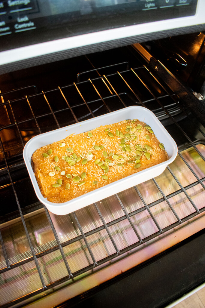 cinnamon sweet potato bread in oven with pumpkin seeds and turbinado sugar on top.