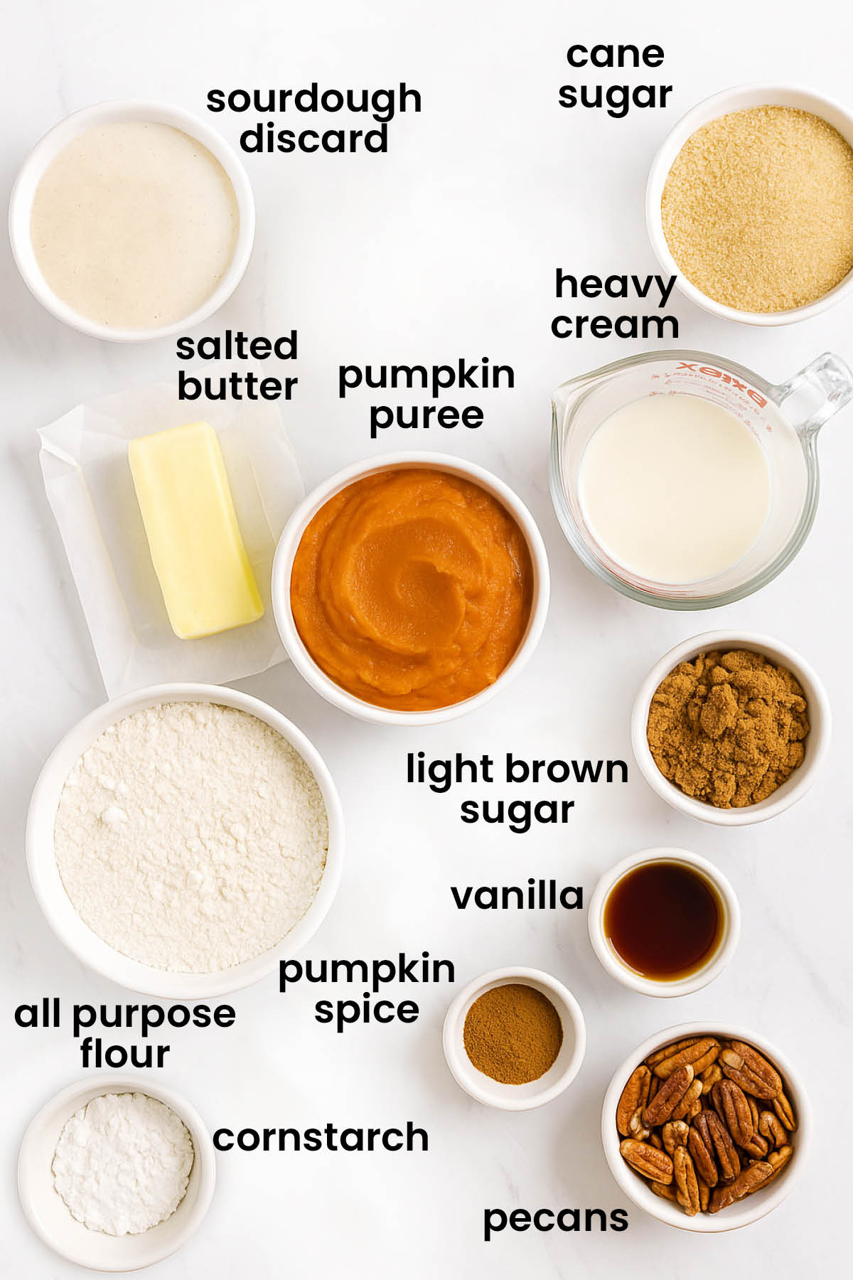 individual ingredients for eggless sourdough pumpkin pie laid out against a white background.