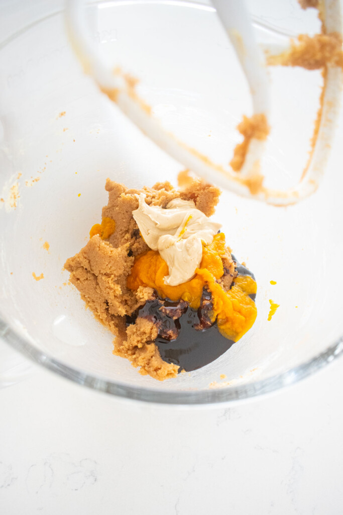 wet ingredients for gluten free gingerbread cookies in a glass mixing bowl on a white marble counter.