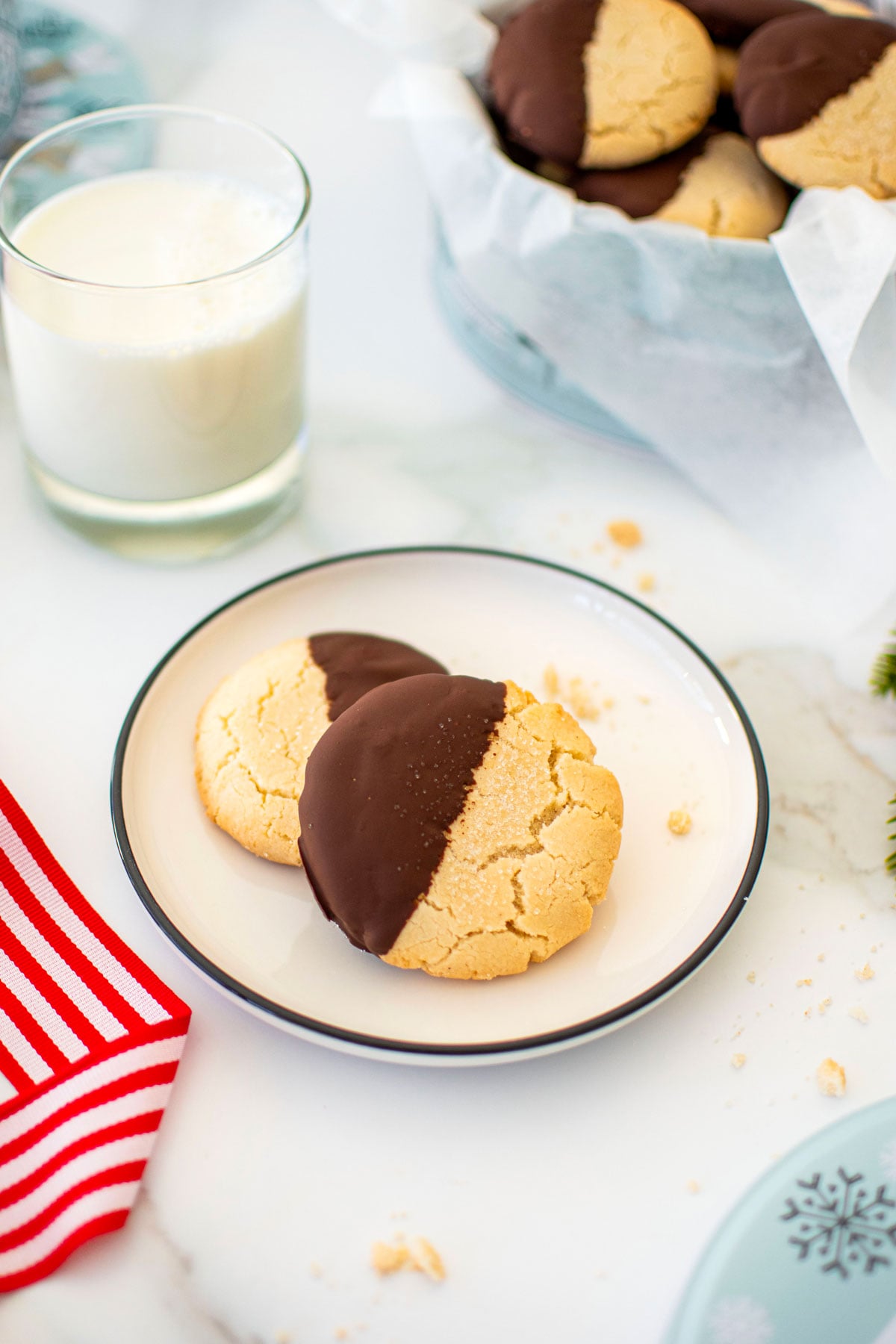 gluten free chocolate peppermint shortbread cookies on a plate on a marble counter with a glass of milk.