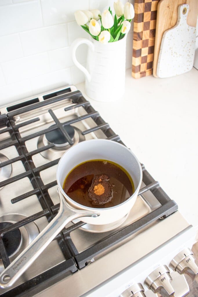 honey, sugar, and maple syrup in a small pot on the stovetop.