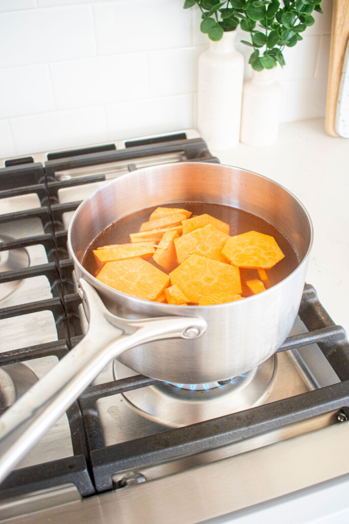 sweet potatoes being boiled in a pot on the stovetop.