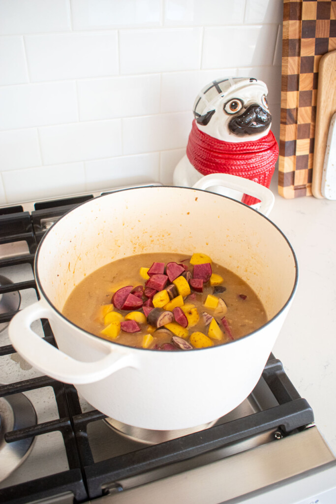turkey carcass soup with bone broth being simmered in a dutch oven on the stovetop.