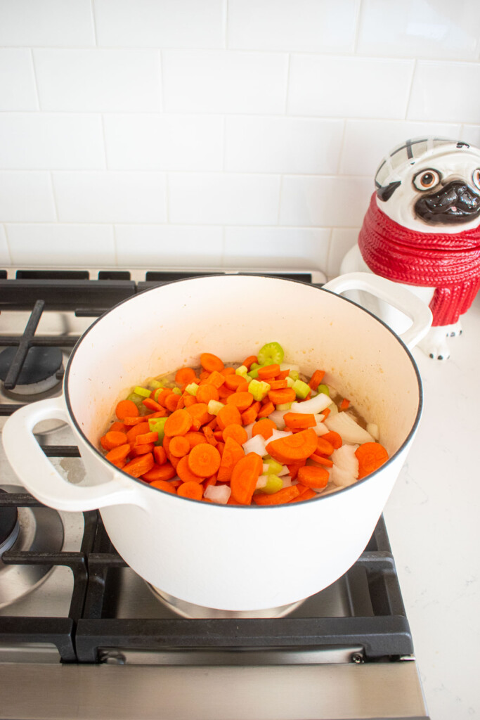 turkey carcass soup with bone broth being simmered in a dutch oven on the stovetop.
