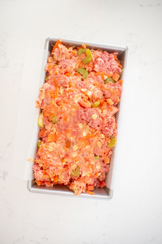 turkey meatloaf for dogs in a loaf pan on a white marble countertop.