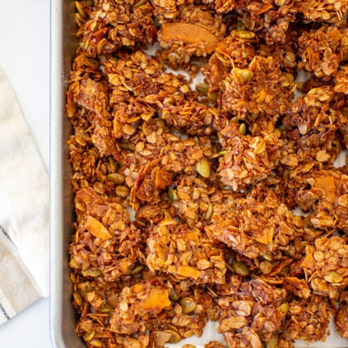 baking sheet of maple cinnamon olive oil granola on a white marble counter.