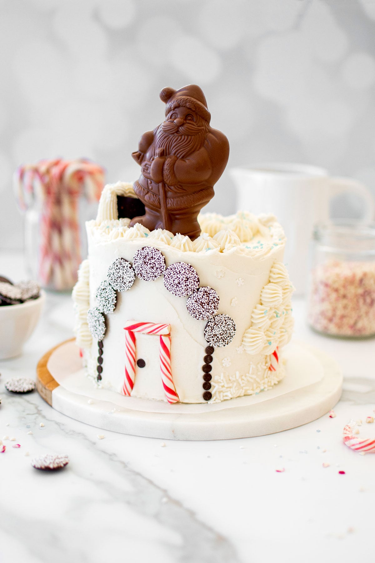christmas eve cake with a chocolate santa on top on a white marble counter.