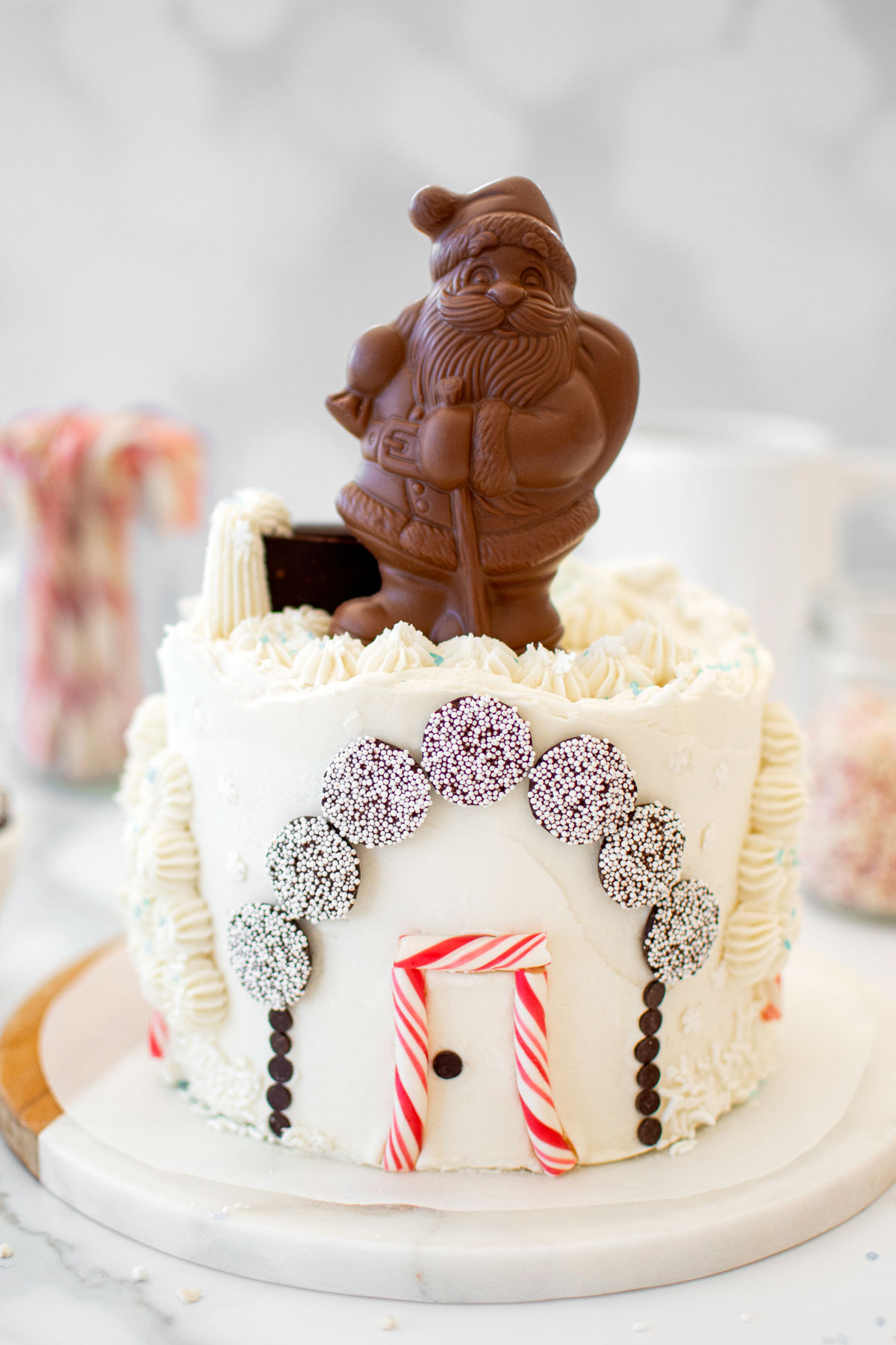 christmas eve cake with a chocolate santa on top on a white marble counter.