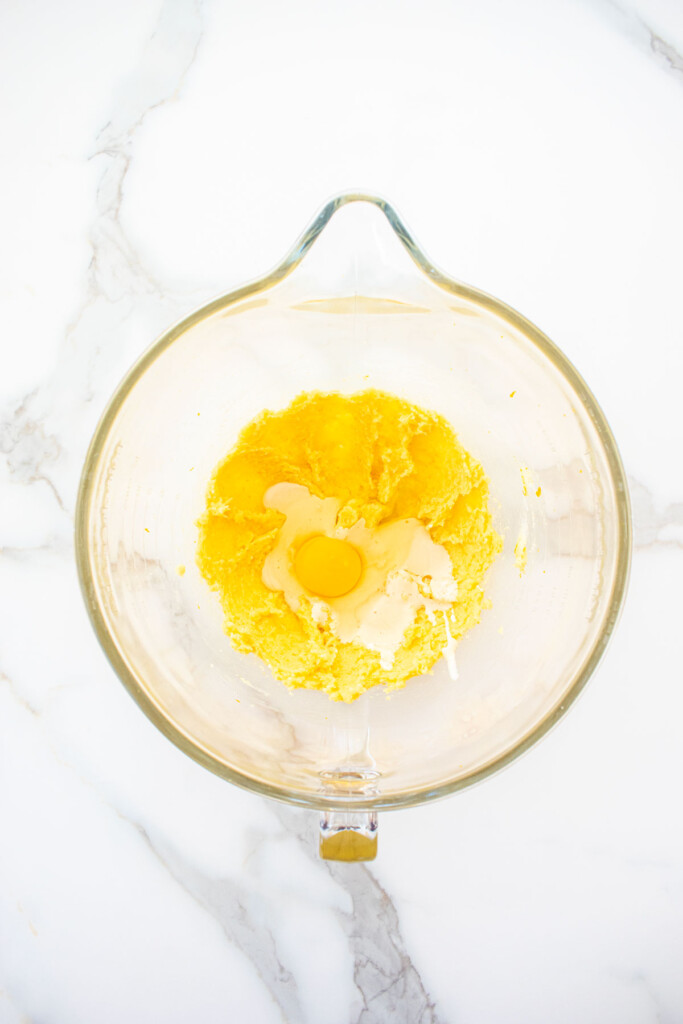 creamed butter and sugar with sourdough discard and egg in a glass mixing bowl on a marble counter.