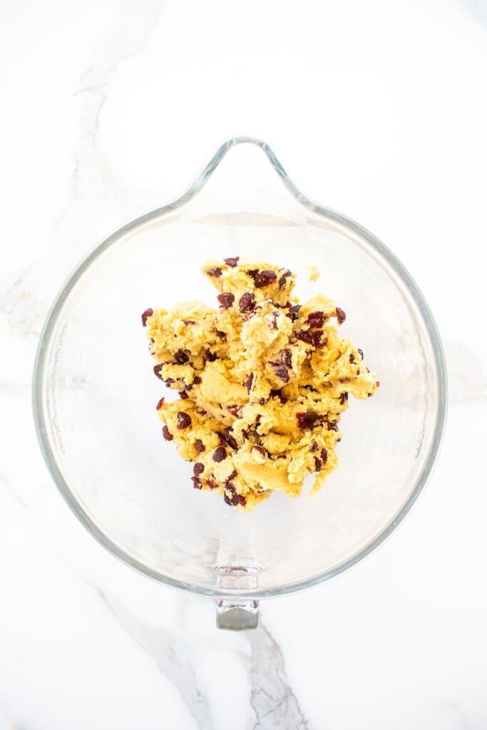 glass mixing bowl with cranberry orange biscotti with sourdough discard cookie dough in it.