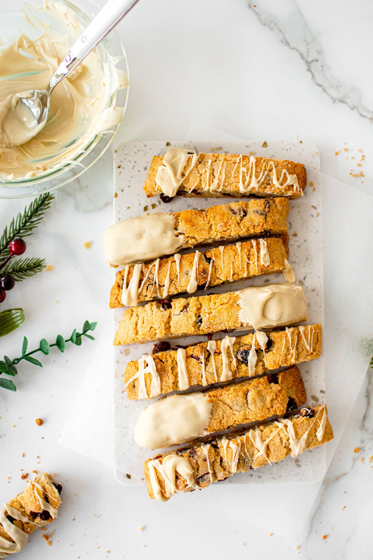 cranberry orange biscotti with sourdough discard pieces on a white marble board.