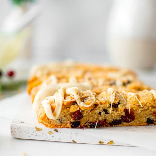 cranberry orange biscotti with sourdough discard pieces on a white marble board.