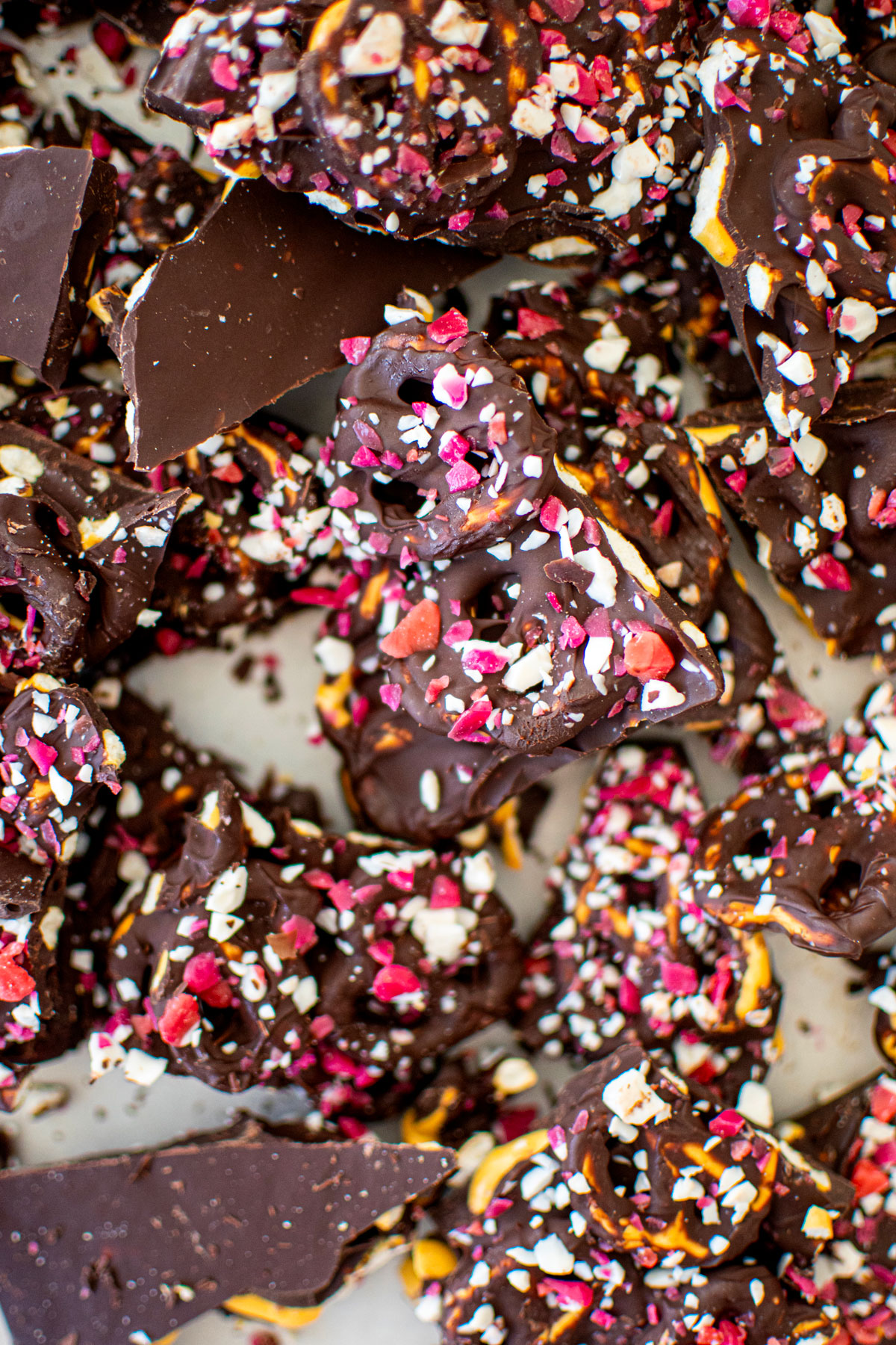 dark chocolate peppermint pretzel bark broken up into pieces on a baking sheet.